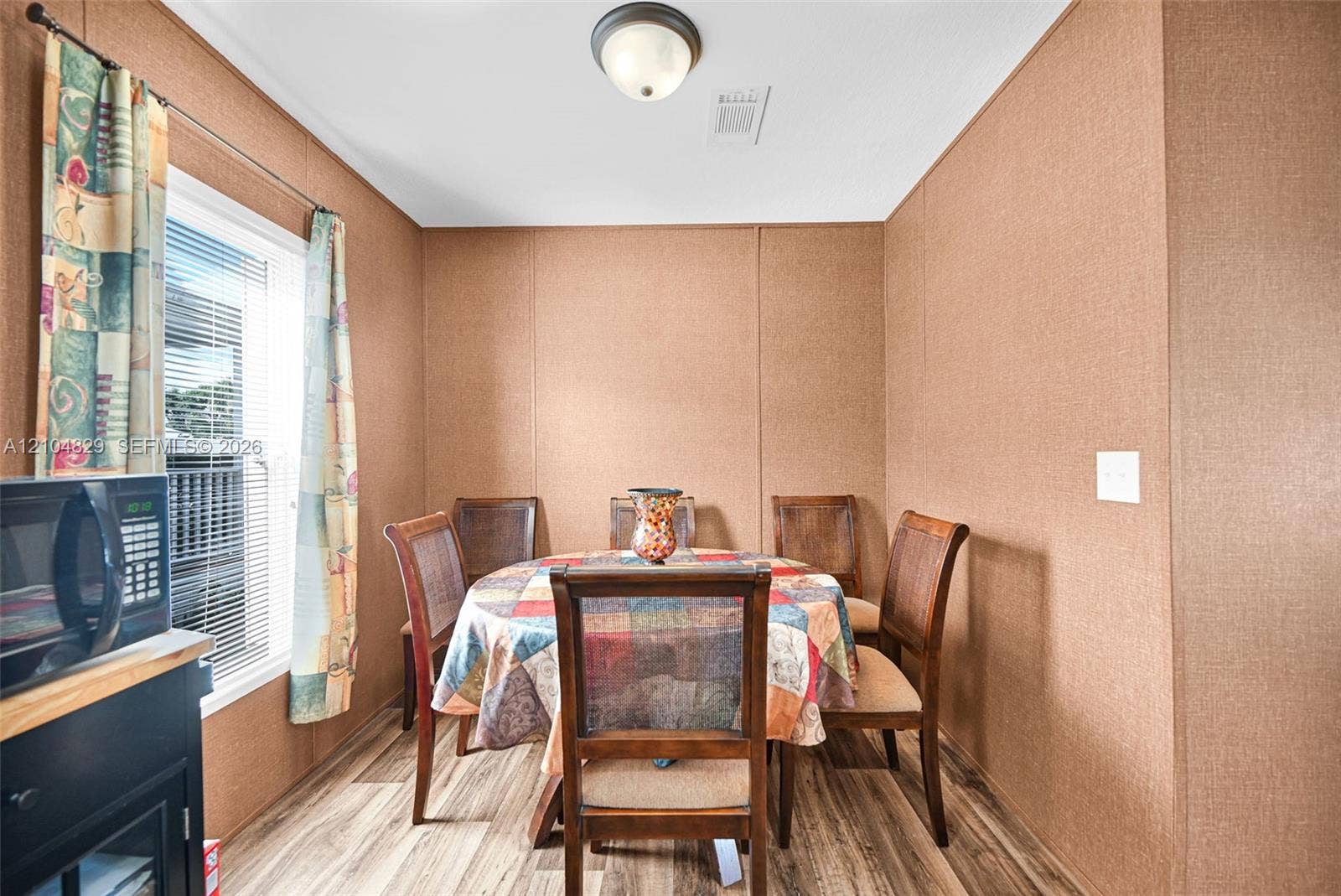 1880 SW 83rd Terrace, Davie, FL 33324 Textured wall panels, wood-finish flooring, and a flush-mount ceiling light fixture