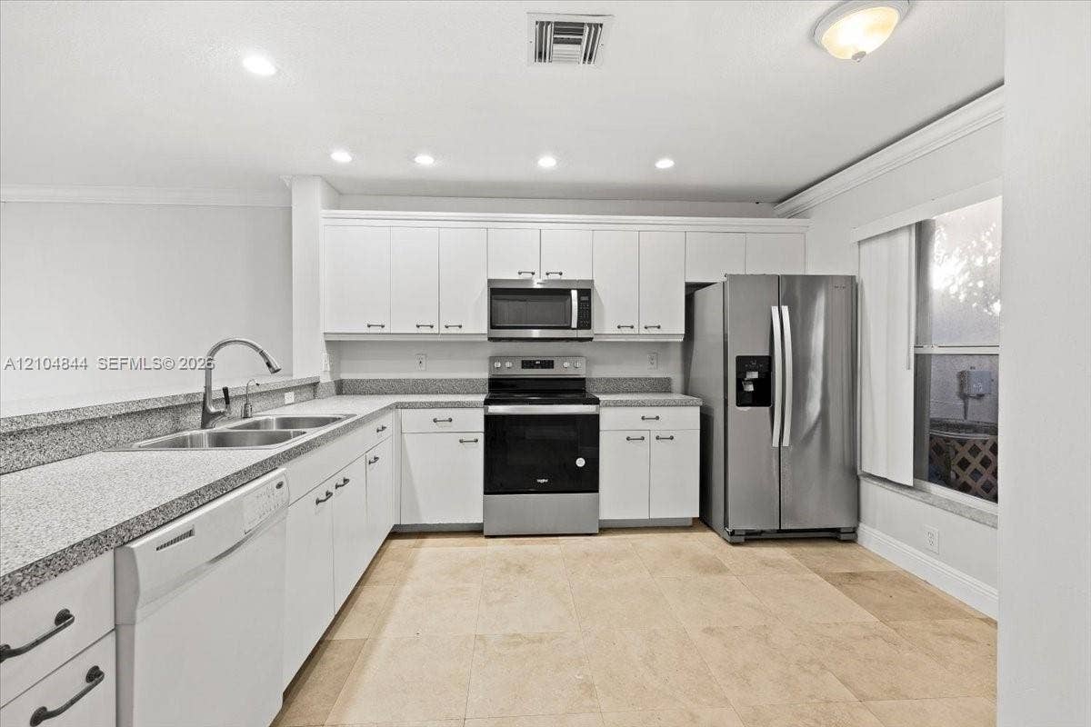 1216 NW 51st Way, Deerfield Beach, FL 33442 Kitchen featuring white cabinetry, speckled stone countertops, stainless steel appliances, a dual-basin undermount sink with a gooseneck faucet, and tile flooring