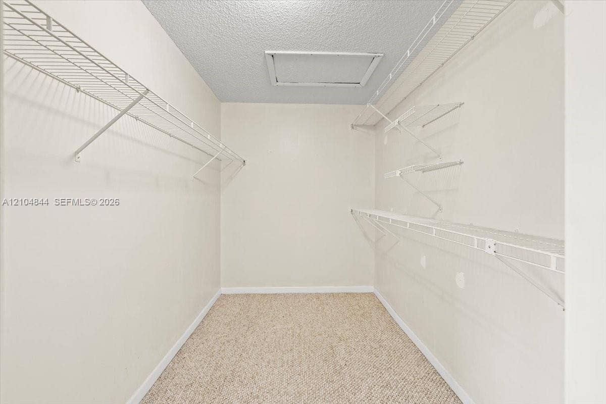 1216 NW 51st Way, Deerfield Beach, FL 33442 Walk-in closet featuring multi-level white wire shelving and neutral wall-to-wall carpeting