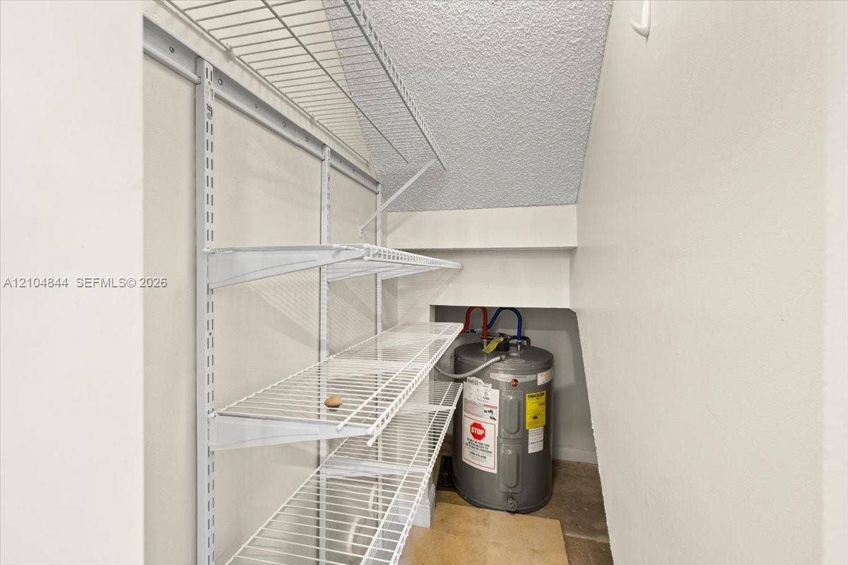 1216 NW 51st Way, Deerfield Beach, FL 33442 Storage area featuring white wire shelving and a water heater