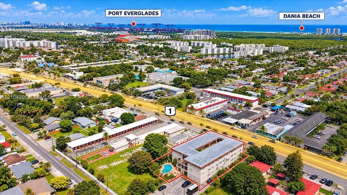Aerial perspective featuring a multi-story building with a central courtyard and an outdoor pool