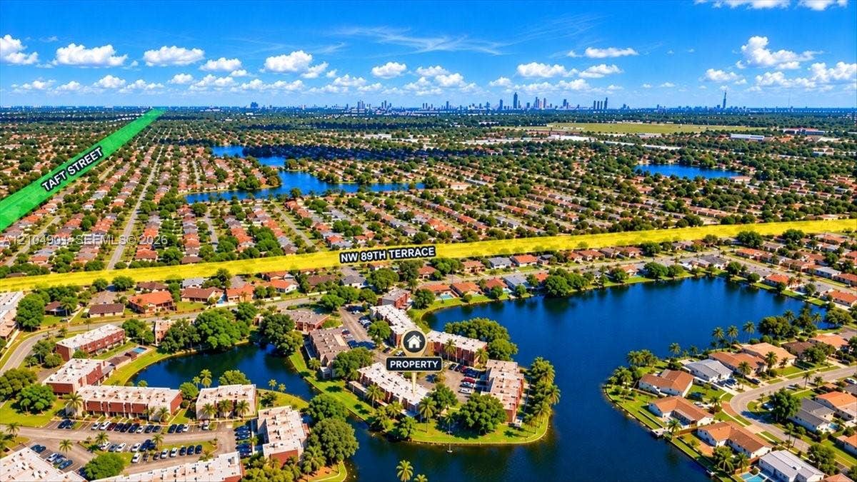 Aerial perspective showcasing a waterfront residential complex situated on a peninsula, featuring surrounding lake frontage and mature tree-lined landscaping