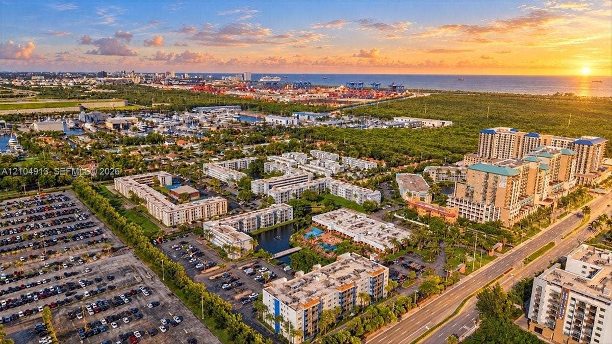 501 E Dania Beach Boulevard, #5-4A, Dania, Dania Beach, FL 33004 Aerial perspective featuring multi-story residential buildings, paved surface parking areas, and a central community pool