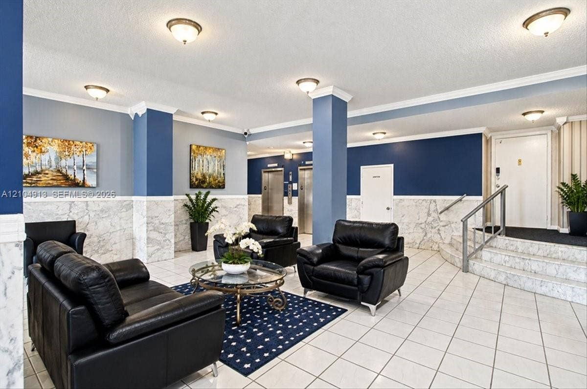 501 E Dania Beach Boulevard, #5-4A, Dania, Dania Beach, FL 33004 Building lobby featuring polished stone tile flooring, wainscoting with stone paneling, recessed and flush-mount lighting, and dual elevator access