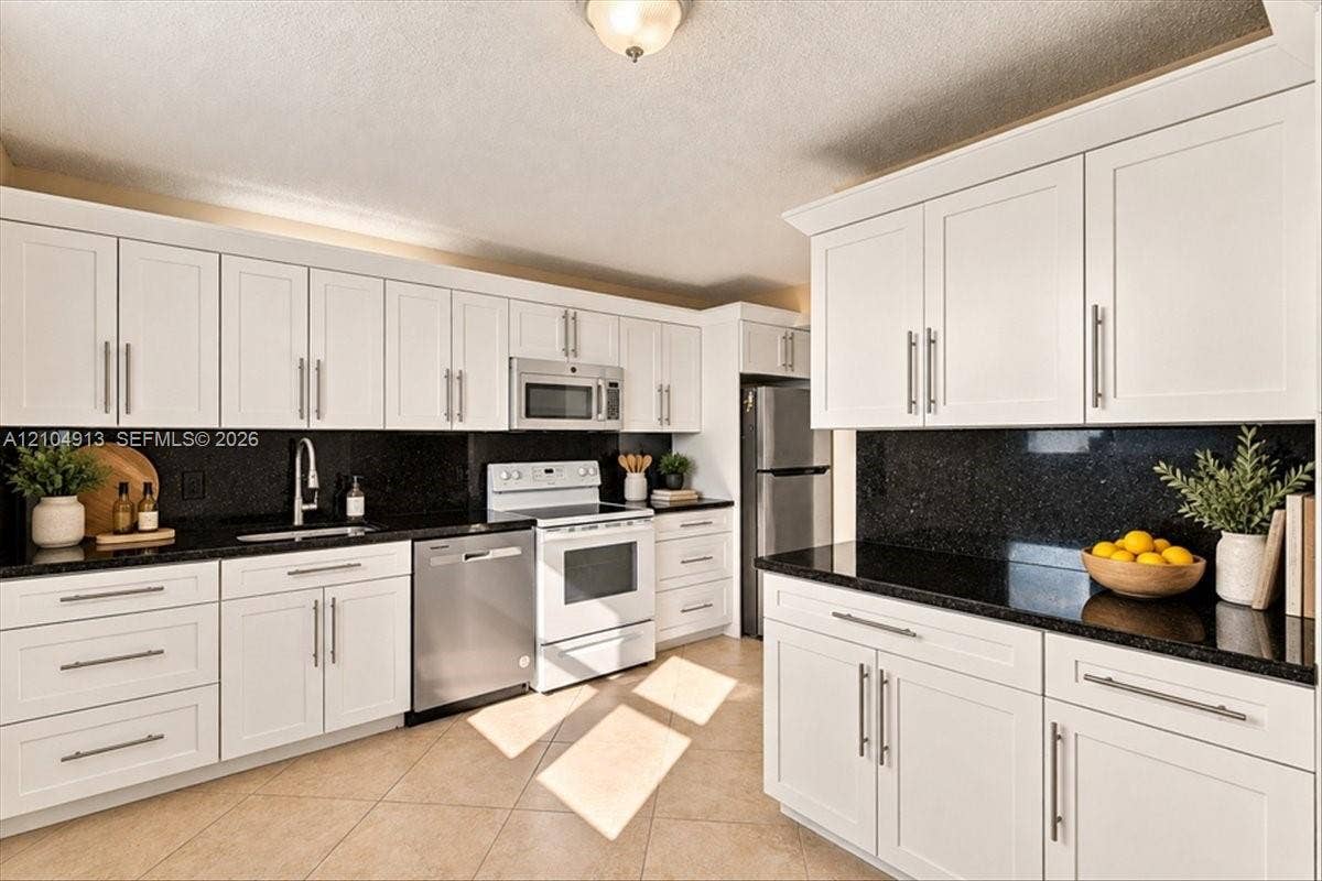 501 E Dania Beach Boulevard, #5-4A, Dania, Dania Beach, FL 33004 Kitchen featuring white shaker-style cabinetry, dark stone countertops, tile flooring, and stainless steel appliances