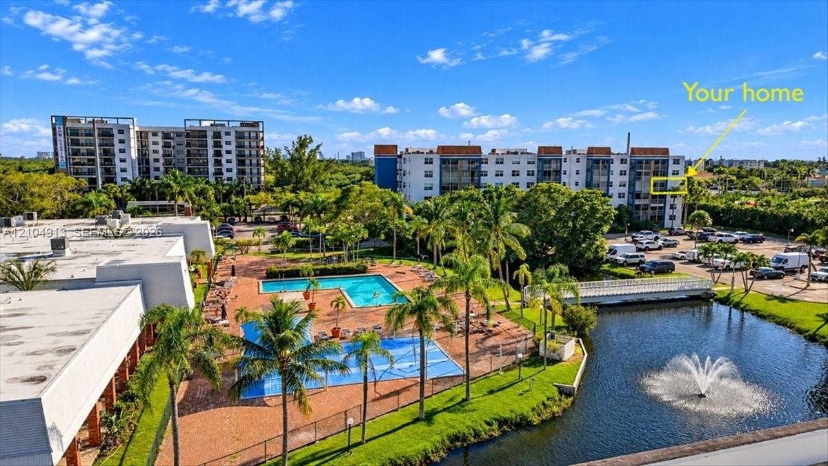 501 E Dania Beach Boulevard, #5-4A, Dania, Dania Beach, FL 33004 Aerial perspective of a multi-story residential building complex featuring an outdoor swimming pool, paved pool deck, water feature with fountain, and mature palm trees