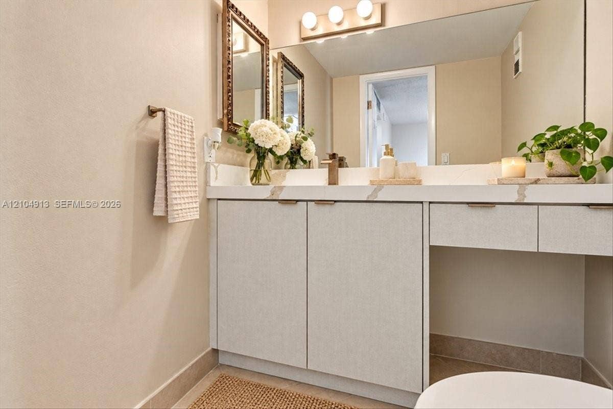 501 E Dania Beach Boulevard, #5-4A, Dania, Dania Beach, FL 33004 Custom vanity with stone-patterned countertop, integrated under-mount sink, metallic hardware, and full-width wall mirror with three-bulb overhead lighting