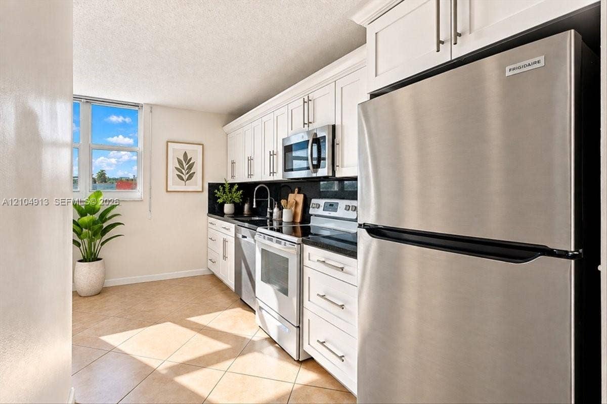 501 E Dania Beach Boulevard, #5-4A, Dania, Dania Beach, FL 33004 Kitchen featuring white shaker-style cabinetry, dark stone countertops, stainless steel appliances, and tile flooring