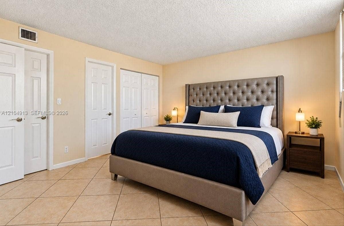 501 E Dania Beach Boulevard, #5-4A, Dania, Dania Beach, FL 33004 Neutral-toned interior featuring ceramic tile flooring, multi-panel doors, and double-door reach-in closet cabinetry