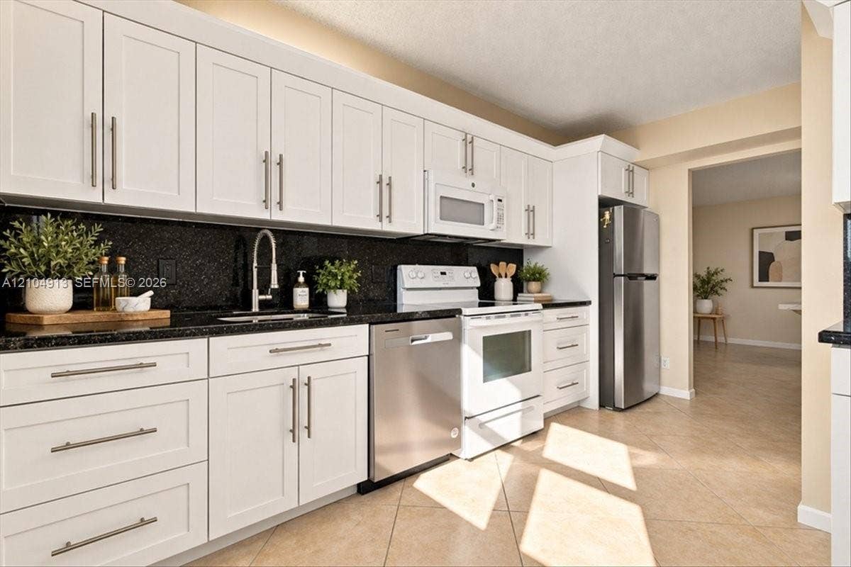 501 E Dania Beach Boulevard, #5-4A, Dania, Dania Beach, FL 33004 Kitchen featuring white shaker-style cabinetry, dark stone countertops, stainless steel appliances, and tile flooring