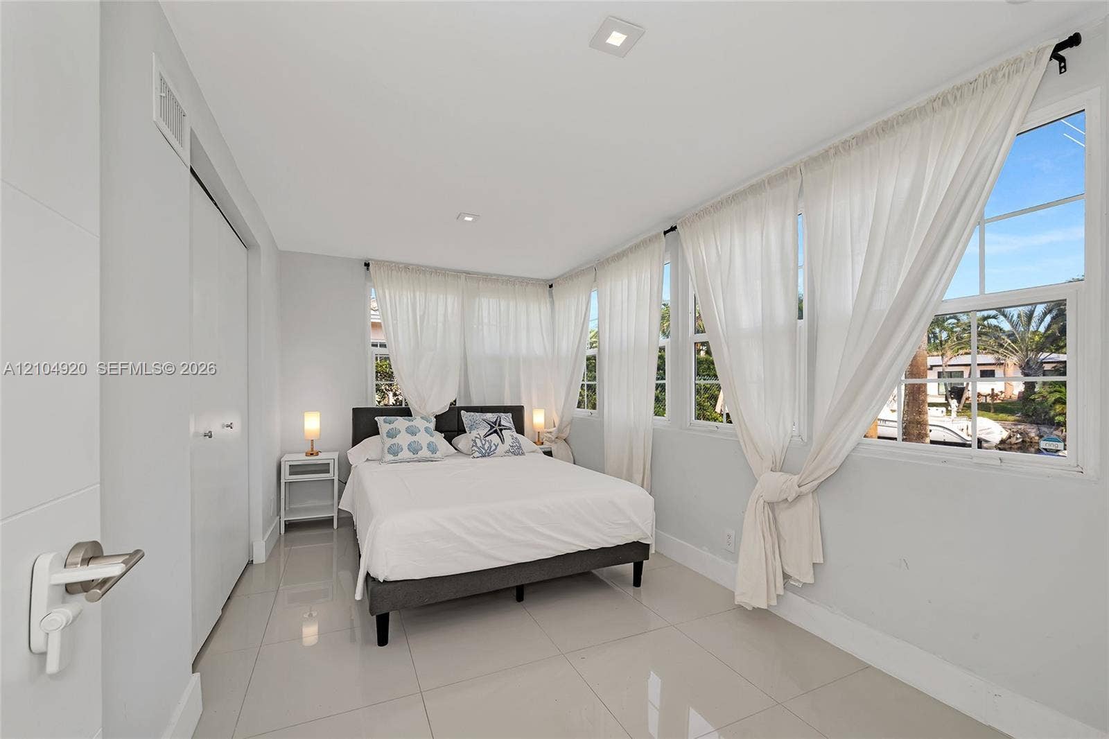 Bright interior space featuring polished tile flooring, recessed lighting, and multiple windows with muntin detailing