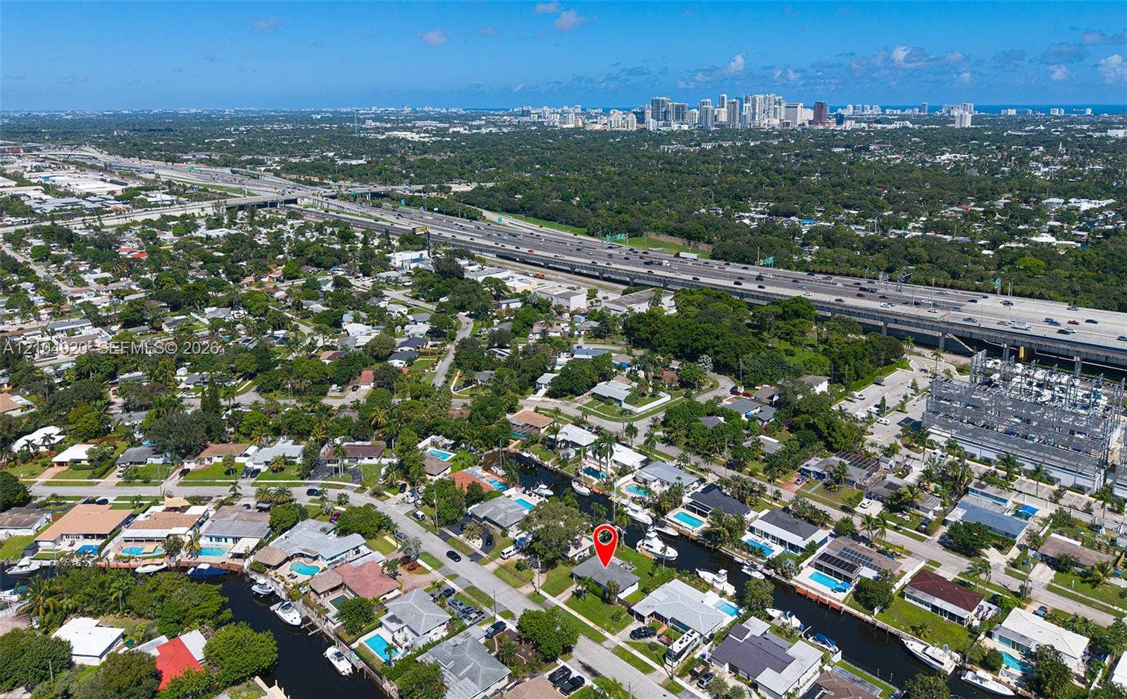 Waterfront showing property featuring direct canal access, a private boat slip, and mature landscaping