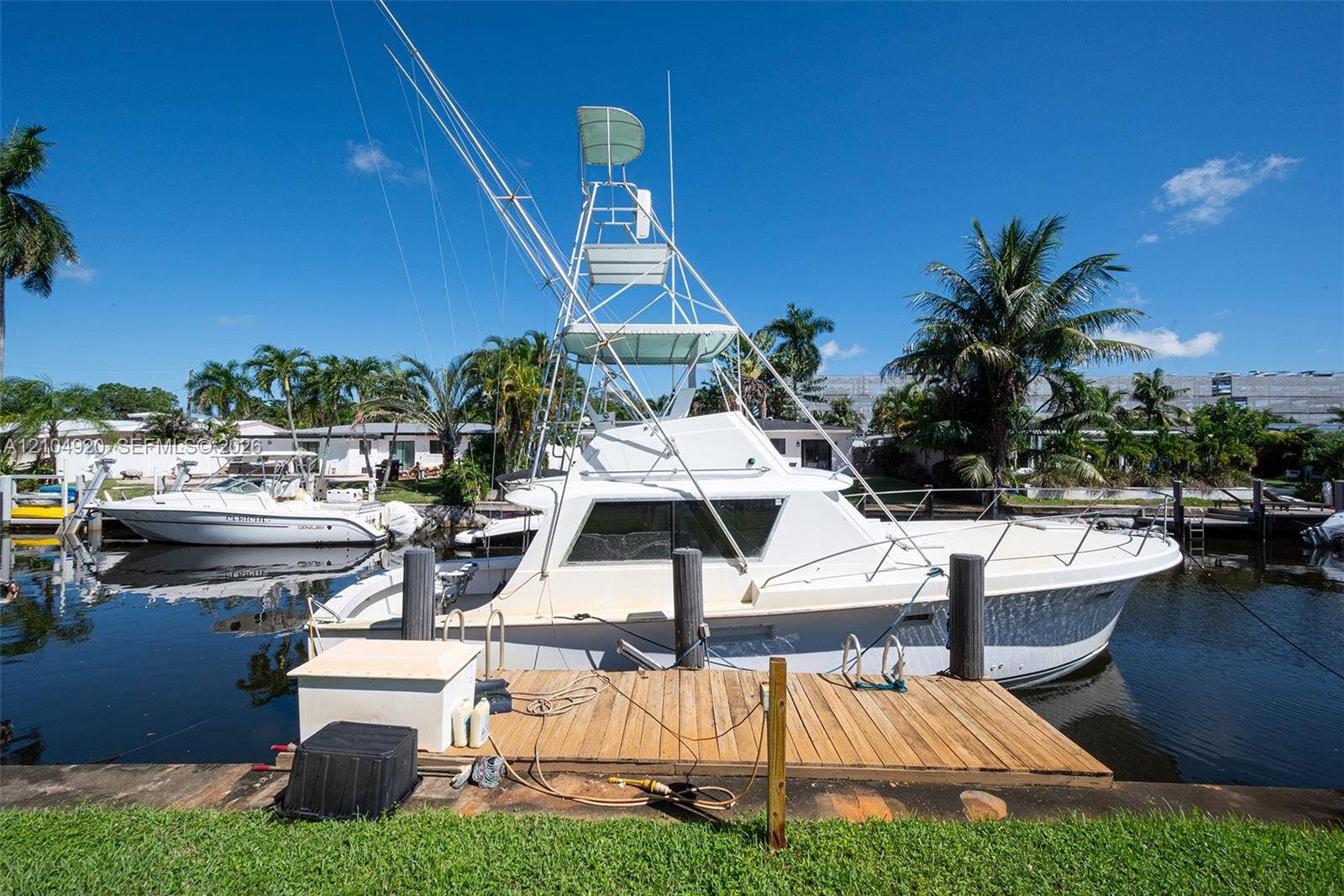 Deep-water canal frontage featuring a private wooden dock and reinforced mooring pilings