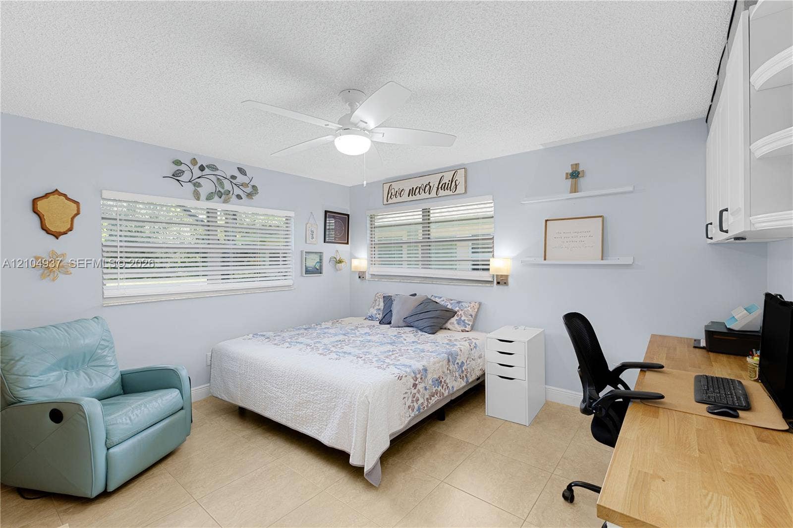 4108 NW 88th Avenue, #3, Coral Springs, FL 33065 Neutral-toned tile flooring, dual windows with horizontal blinds, built-in upper cabinetry, and a ceiling fan with integrated lighting