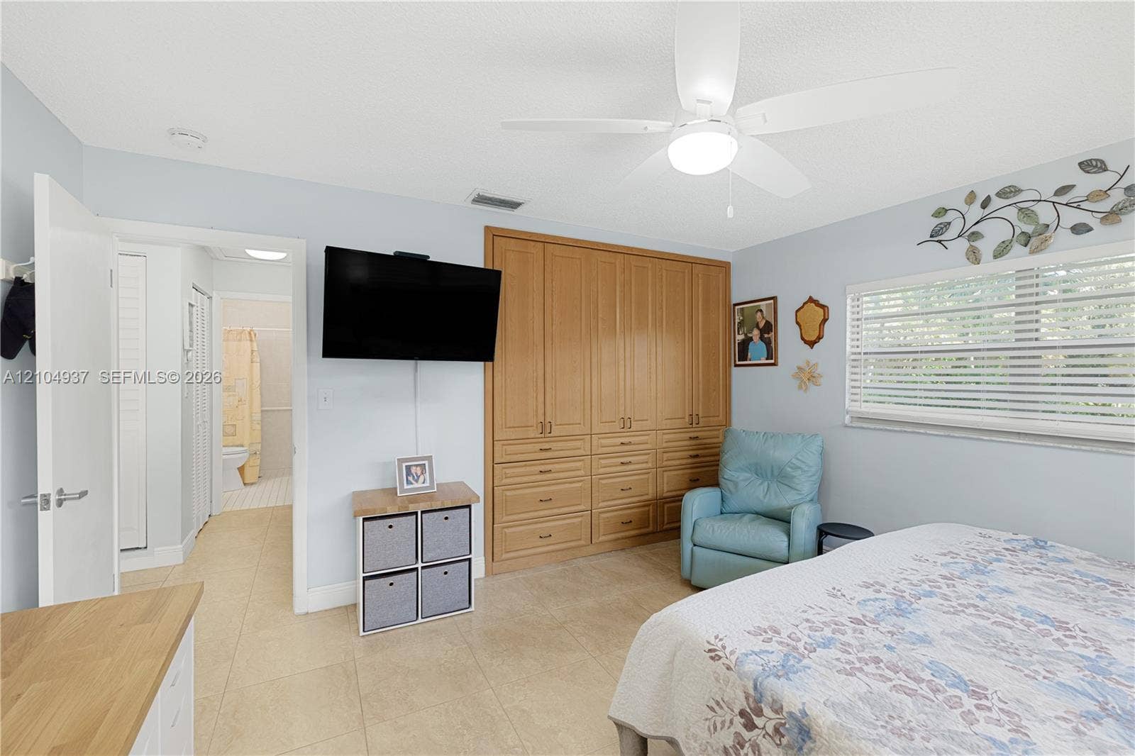 4108 NW 88th Avenue, #3, Coral Springs, FL 33065 Built-in light-wood cabinetry, ceiling fan with integrated lighting, horizontal window blinds, and tile flooring