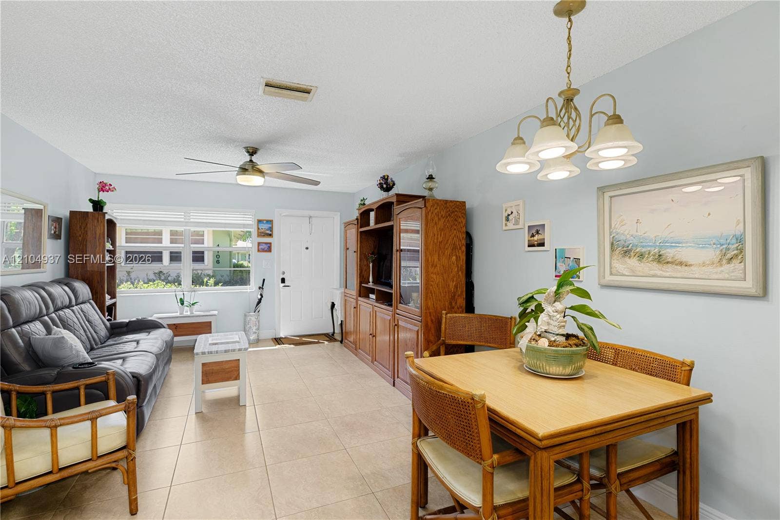 4108 NW 88th Avenue, #3, Coral Springs, FL 33065 Neutral-tone tile flooring, multi-pane windows, ceiling fan, and ornate five-light chandelier