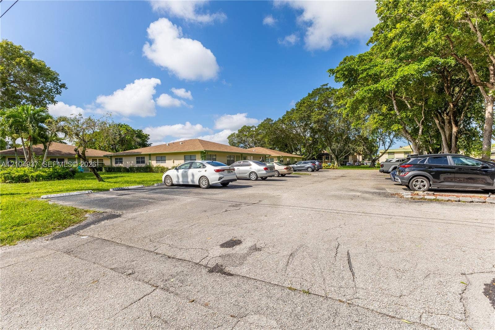 4108 NW 88th Avenue, #3, Coral Springs, FL 33065 Asphalt parking lot featuring designated surface parking and mature trees