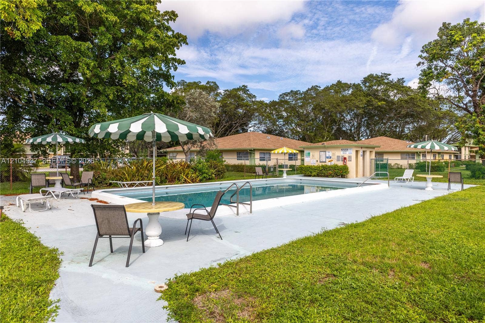 4108 NW 88th Avenue, #3, Coral Springs, FL 33065 In-ground swimming pool with surrounding concrete deck, mature perimeter landscaping, and dedicated pool house facility