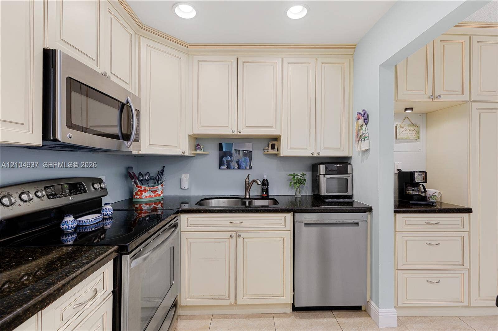 4108 NW 88th Avenue, #3, Coral Springs, FL 33065 Kitchen featuring off-white shaker cabinetry, dark stone countertops, stainless steel appliances, an undermount double-basin sink with a gooseneck faucet, and recessed lighting