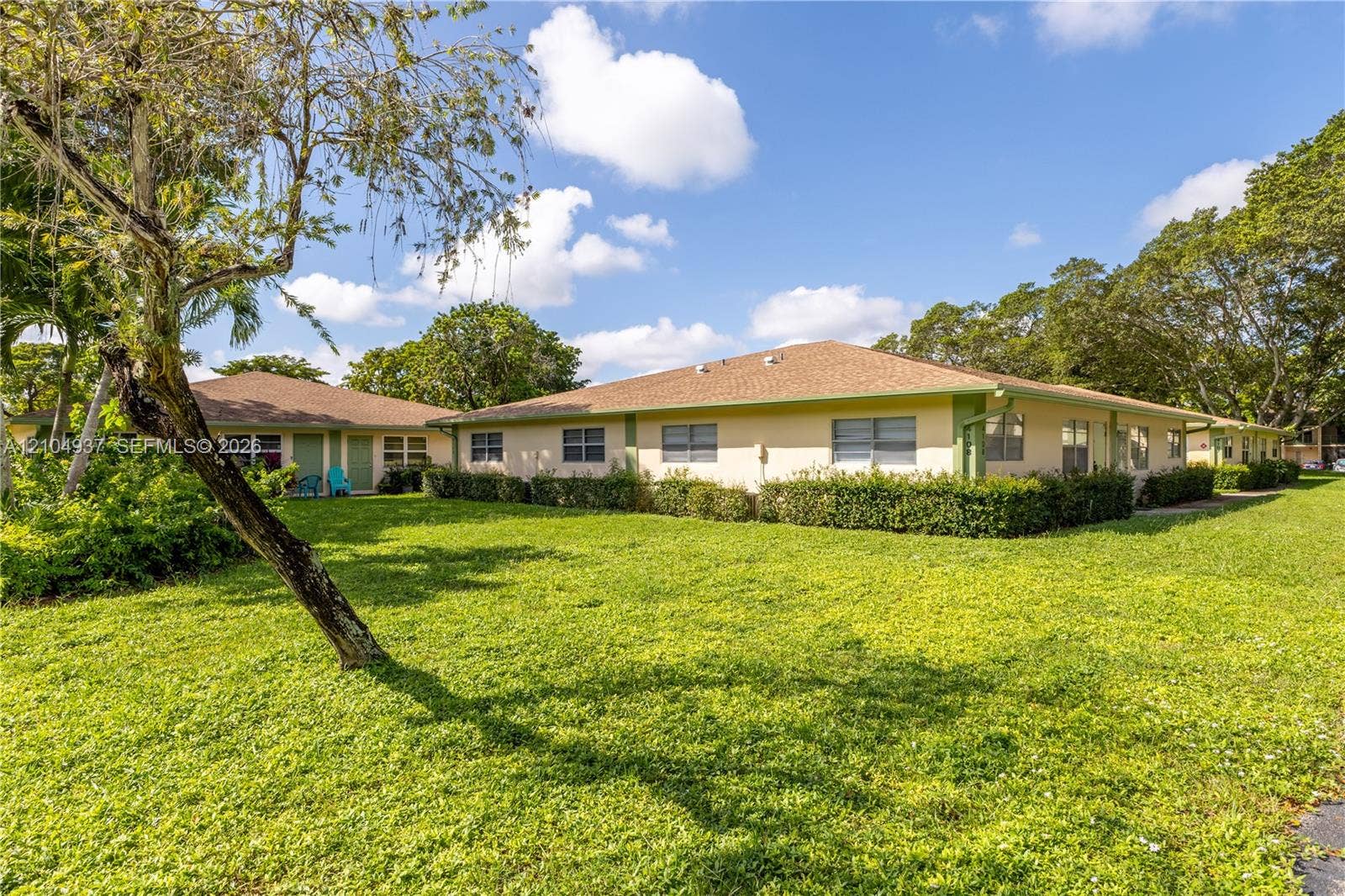 4108 NW 88th Avenue, #3, Coral Springs, FL 33065 Single-story exterior featuring a hip roof, stucco siding, horizontal sliding windows, and established perimeter shrubbery set on a expansive lawn