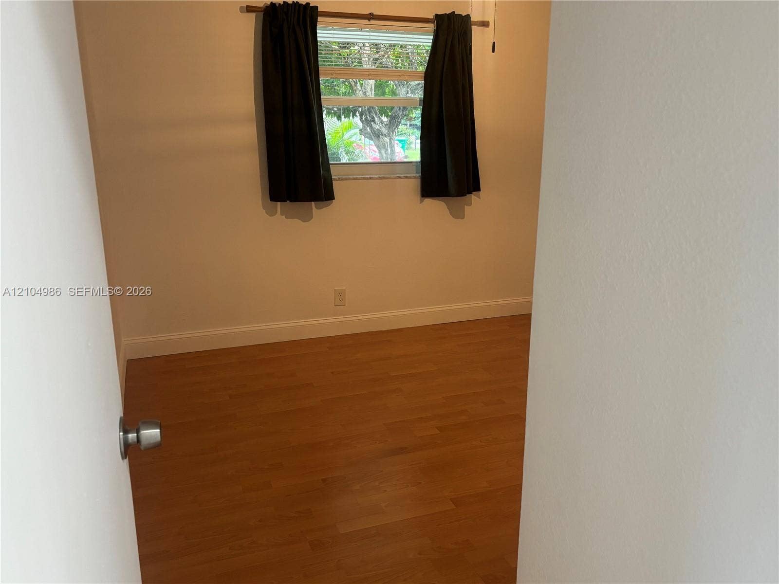 Davie, FL 33314 Room featuring wood-finish flooring, neutral-toned walls, and a horizontal sliding window