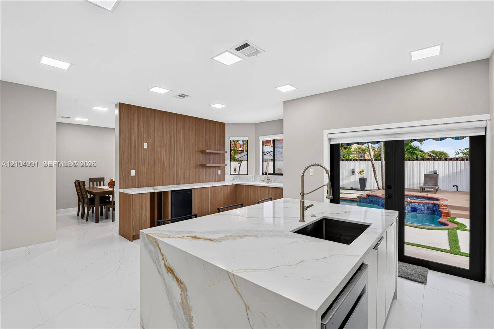 15217 SW 36th Terrace, #0, Miami, Miami, FL 33185 Kitchen featuring an island with a stone-finish countertop, undermount sink, matte black gooseneck faucet, wood-finish cabinetry, and recessed lighting