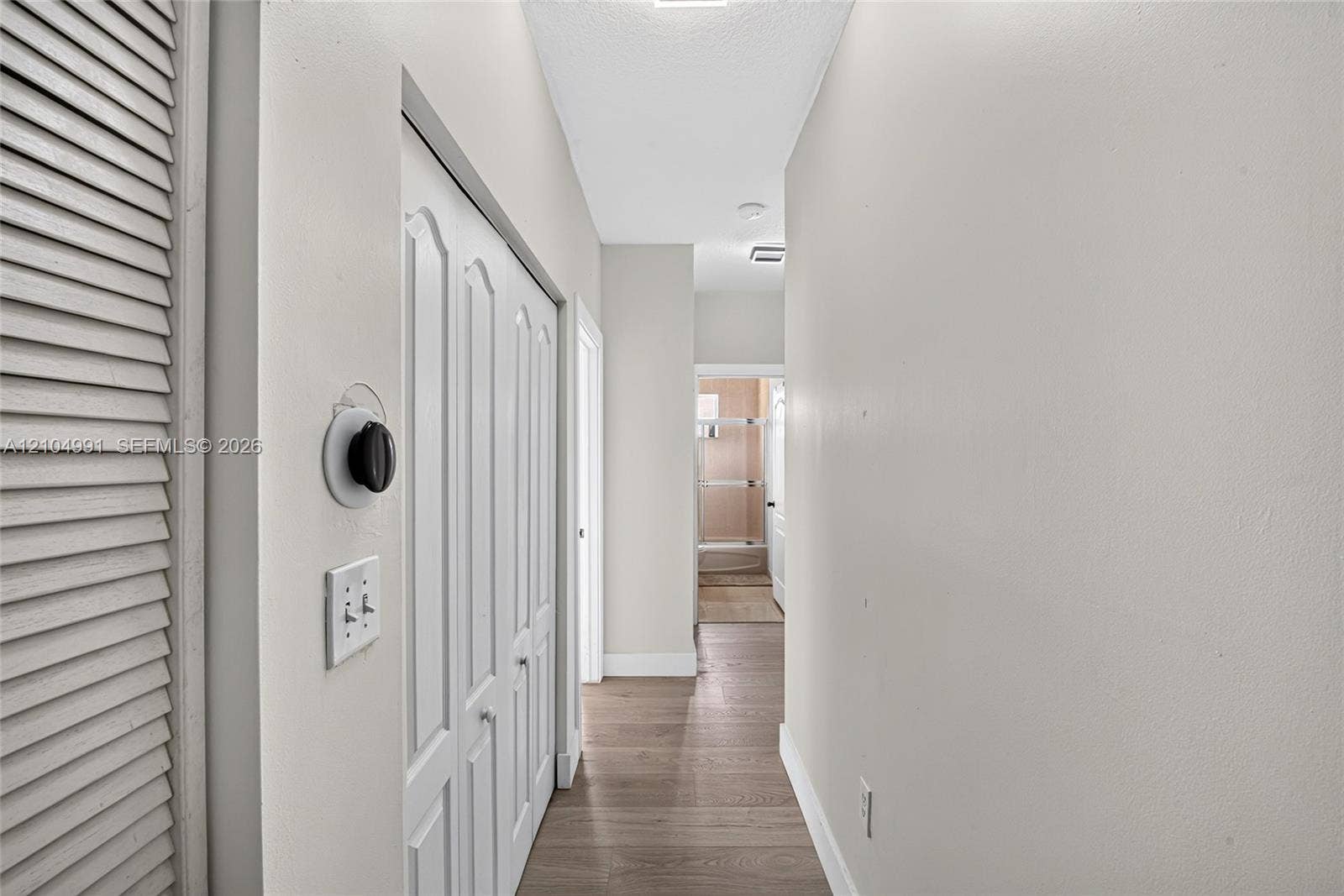 15217 SW 36th Terrace, #0, Miami, Miami, FL 33185 Hallway featuring wood-finish flooring, white louvered closet doors, and a double-panel interior closet door