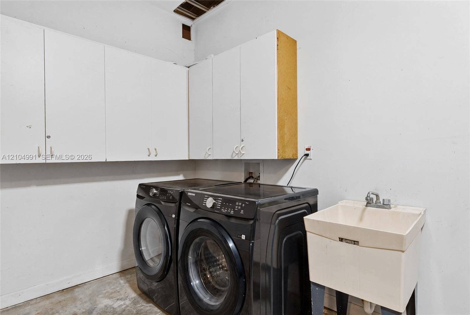 15217 SW 36th Terrace, #0, Miami, Miami, FL 33185 Wall-mounted white storage cabinetry, utility sink with chrome faucet, and dedicated laundry hookups
