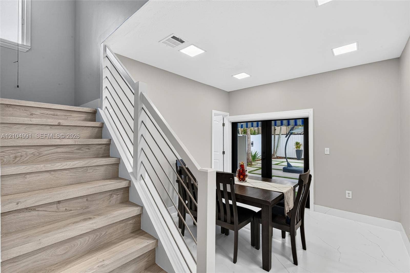 15217 SW 36th Terrace, #0, Miami, Miami, FL 33185 Staircase featuring wood-finish treads, custom white horizontal metal railing, recessed ceiling lighting, and large-format tile flooring