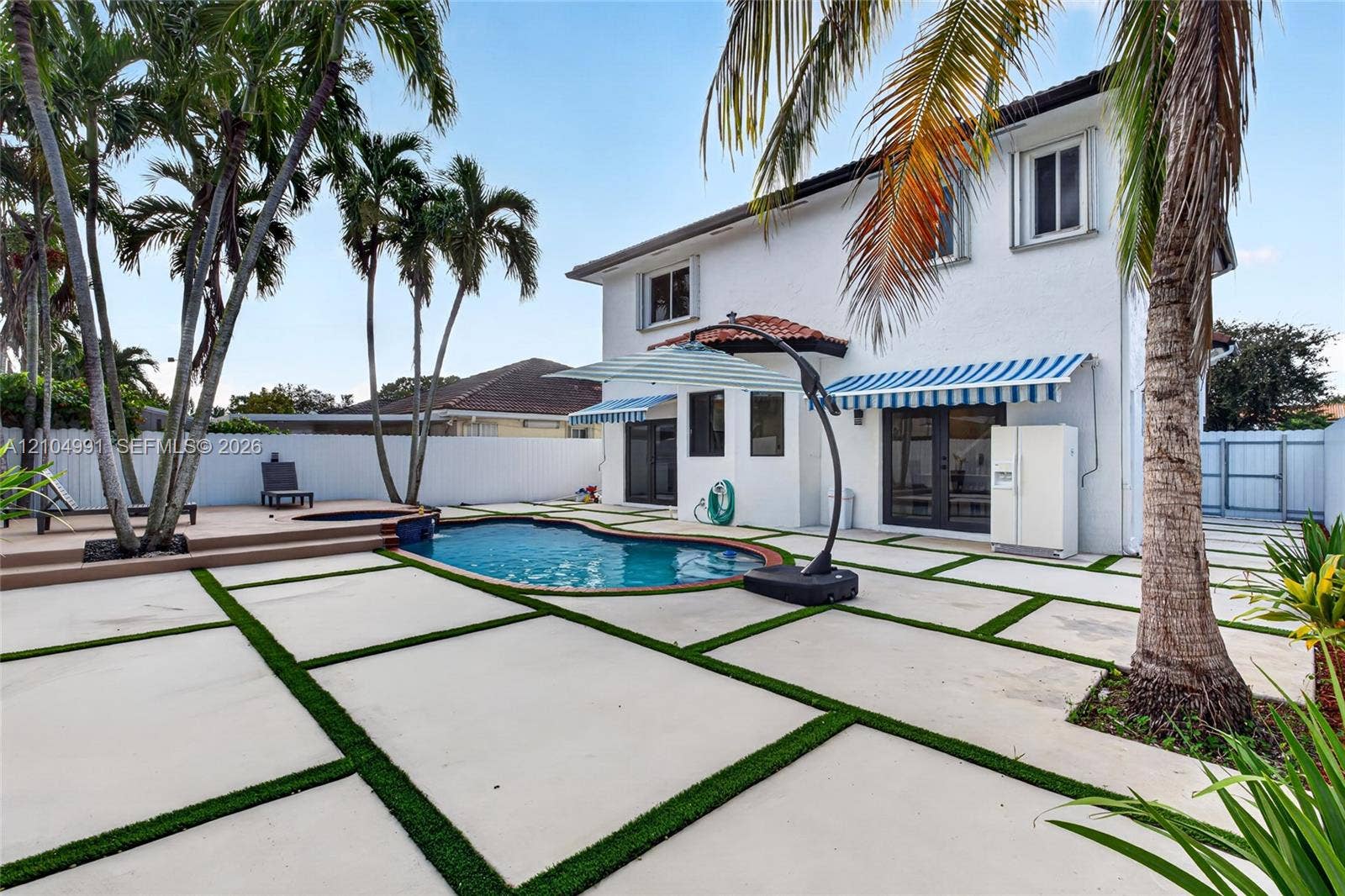 15217 SW 36th Terrace, #0, Miami, Miami, FL 33185 Backyard featuring an in-ground swimming pool, raised composite deck, custom concrete paver patio with turf detailing, and privacy fencing