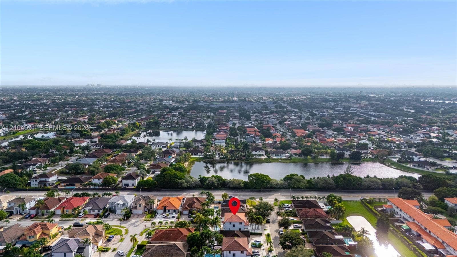 15217 SW 36th Terrace, #0, Miami, Miami, FL 33185 Aerial perspective of a multi-story residence with a pitched tile roof, situated in a suburban setting featuring nearby ponds and mature canopy trees