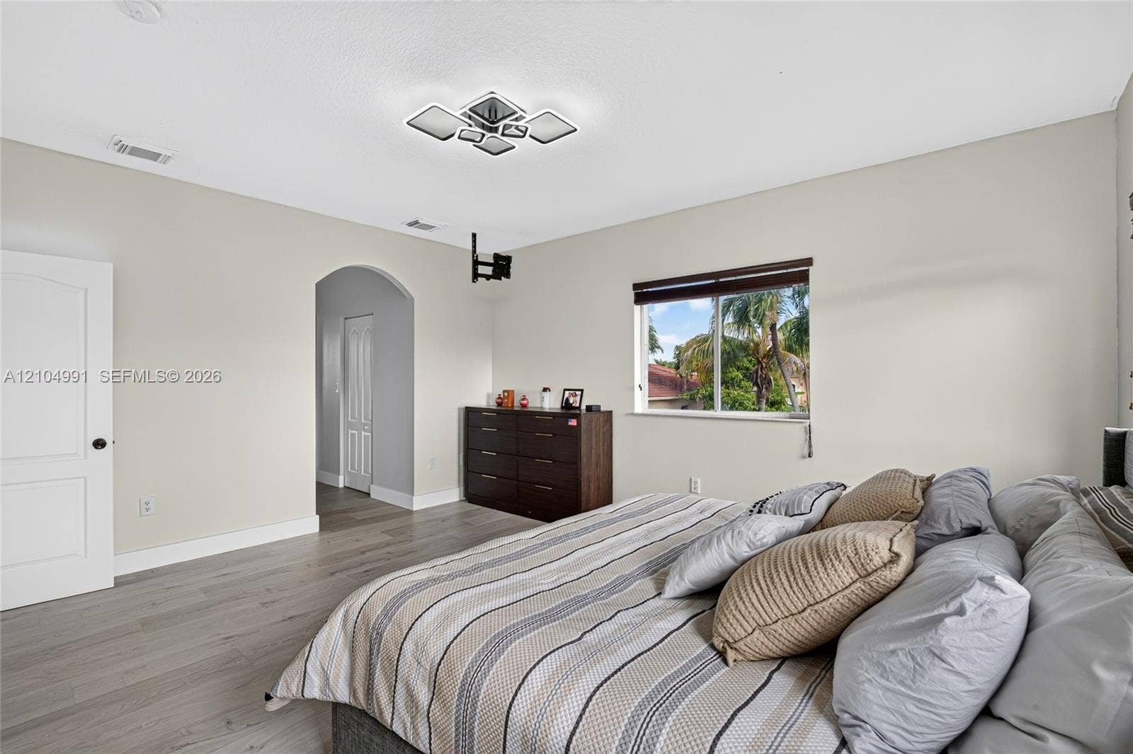 15217 SW 36th Terrace, #0, Miami, Miami, FL 33185 Wood-finish flooring, geometric ceiling lighting, arched entryway, and single-hung window with dark window treatments