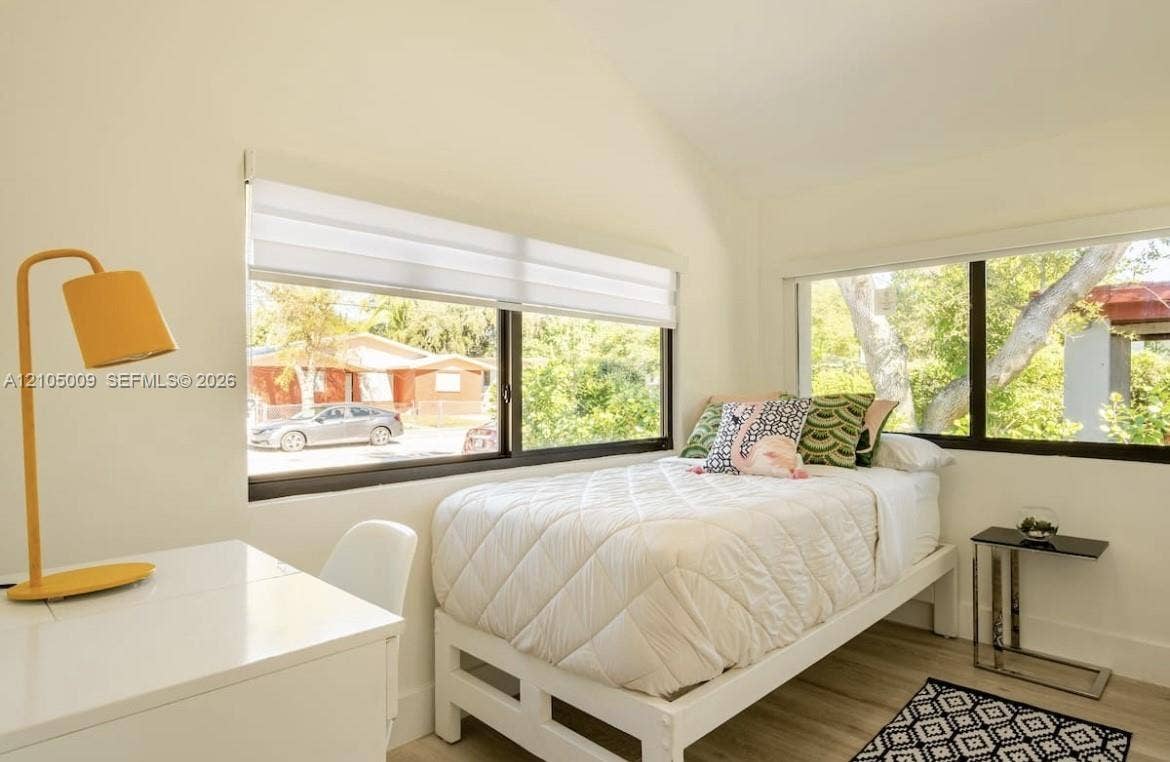 254 NW 51st Street, Miami, Miami, FL 33127 Wood-finish flooring, white walls, and multiple windows with roller shades