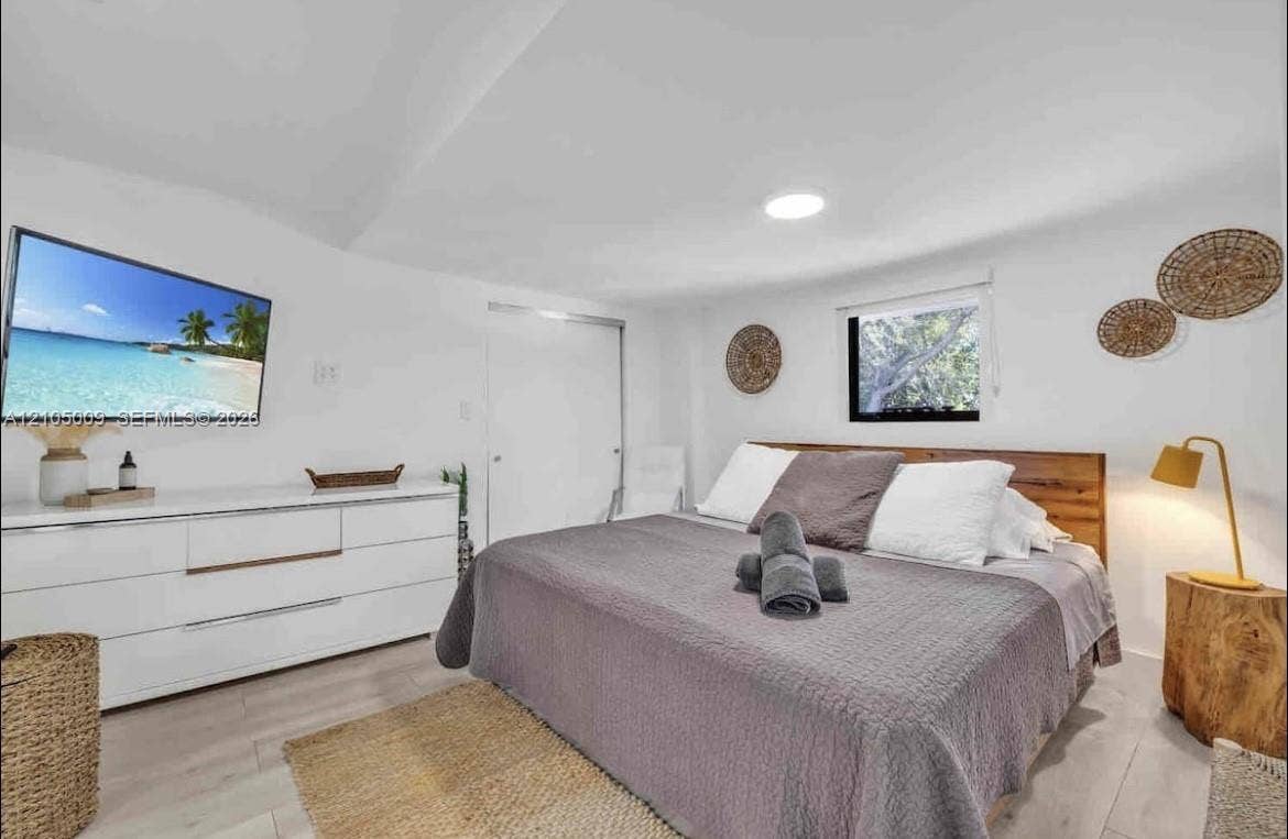 254 NW 51st Street, Miami, Miami, FL 33127 White walls, wood-finish flooring, recessed ceiling lighting, a window, and a built-in closet with sliding doors