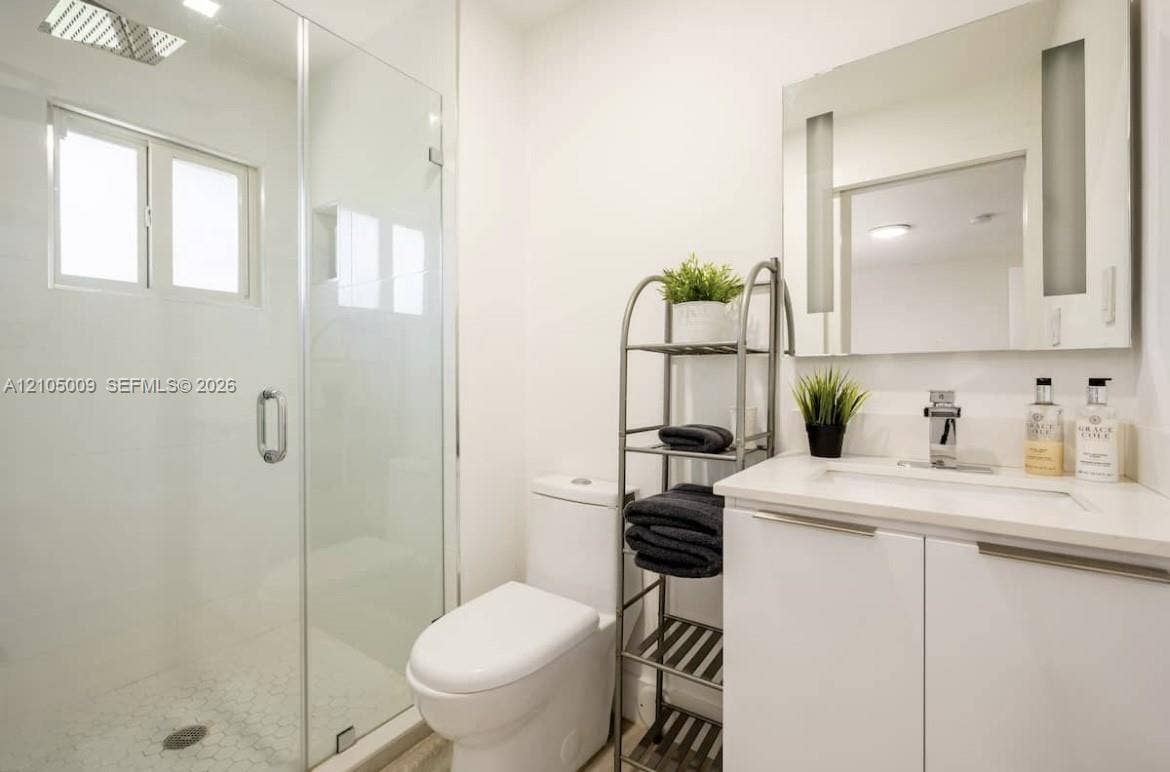254 NW 51st Street, Miami, Miami, FL 33127 Glass-enclosed shower with white tiled walls and a hex-tile floor