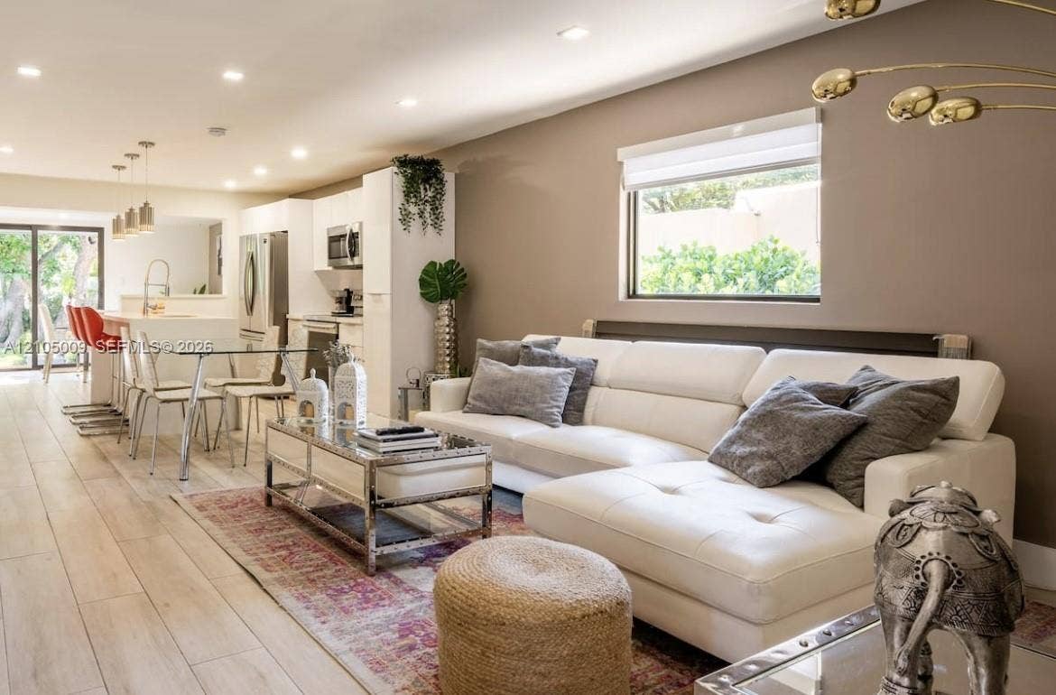 254 NW 51st Street, Miami, Miami, FL 33127 Open-concept living area with light wood-finish flooring, recessed lighting, and a kitchen featuring stainless steel appliances