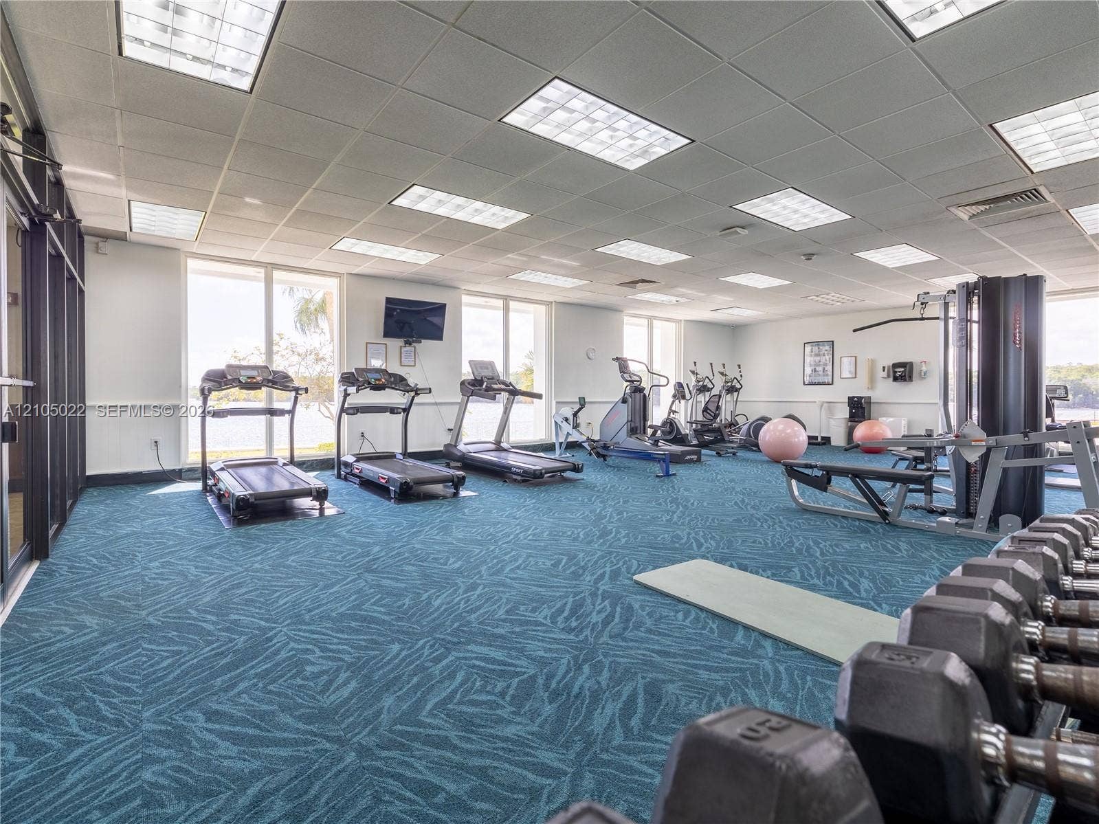 500 Bayview Drive, #1520, Sunny Isles Beach, Sunny Isles Beach, FL 33160 Fitness center with expansive windows, patterned carpet flooring, and a drop ceiling with integrated lighting
