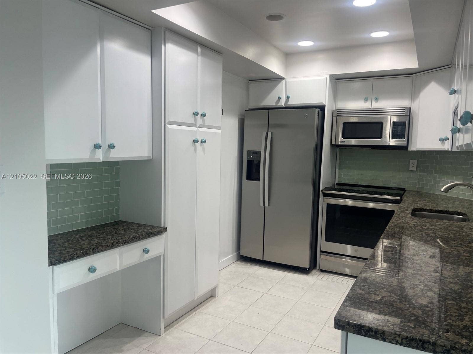 500 Bayview Drive, #1520, Sunny Isles Beach, Sunny Isles Beach, FL 33160 White cabinetry with decorative knobs, stainless steel appliances, dark stone-finish countertops, tiled backsplash, and recessed lighting
