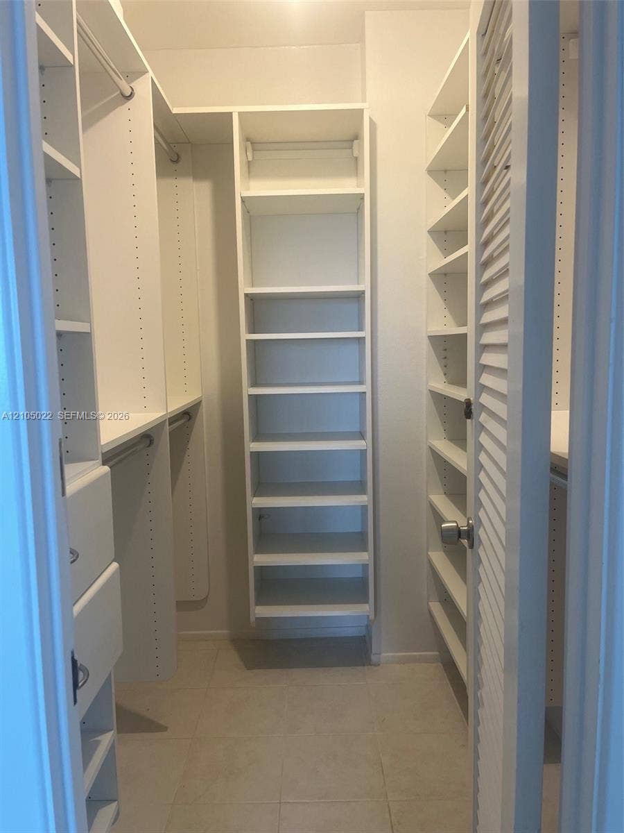 500 Bayview Drive, #1520, Sunny Isles Beach, Sunny Isles Beach, FL 33160 Custom closet system featuring white shelving units, integrated drawers, and hanging rods