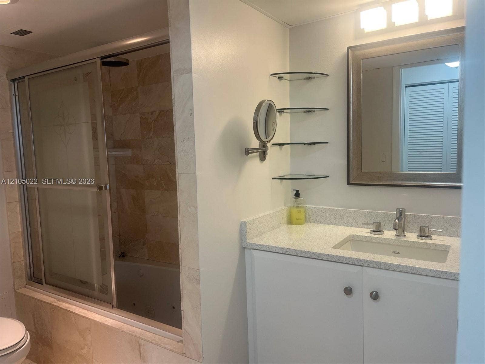 500 Bayview Drive, #1520, Sunny Isles Beach, Sunny Isles Beach, FL 33160 Vanity with light-colored countertop and integrated sink, framed mirror, and chrome fixtures