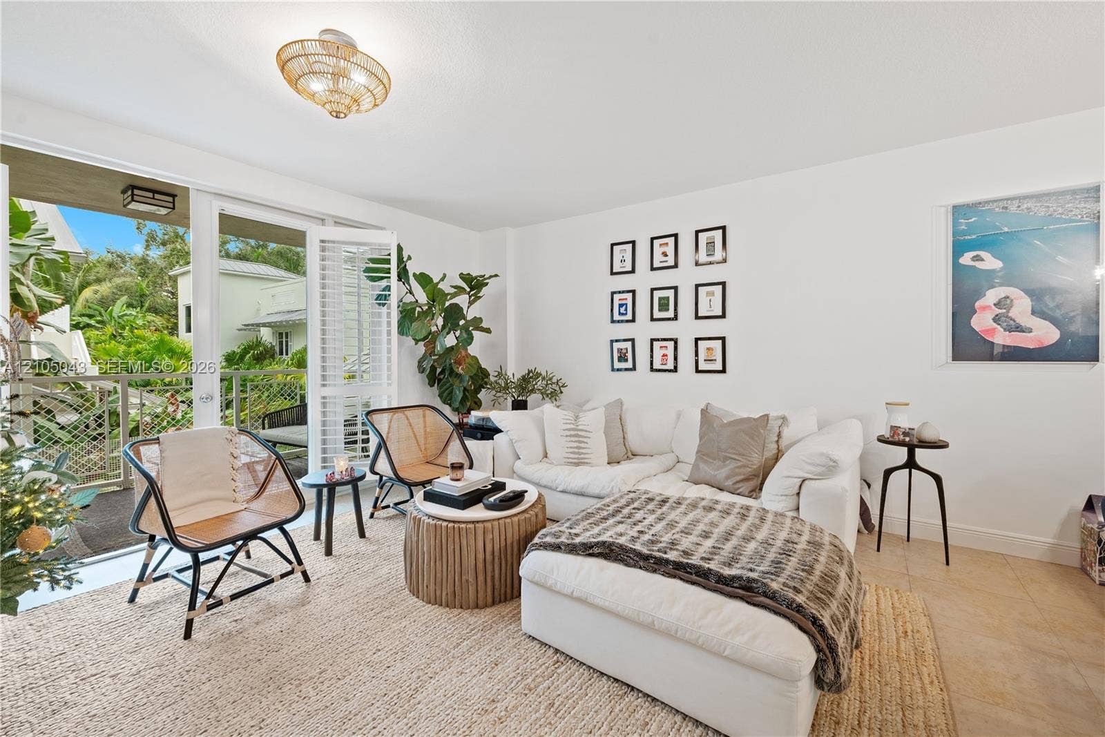 3540 Main Highway, #207, Miami, FL 33133 Kitchen featuring wood-toned cabinetry, stone countertops, stainless steel appliances, a multi-bulb linear pendant light, and neutral tile flooring