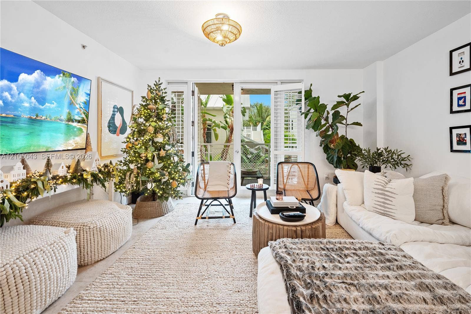 3540 Main Highway, #207, Miami, FL 33133 Living area featuring glass-paned double doors, wood-finish flooring, a semi-flush mount rattan light fixture, and white walls