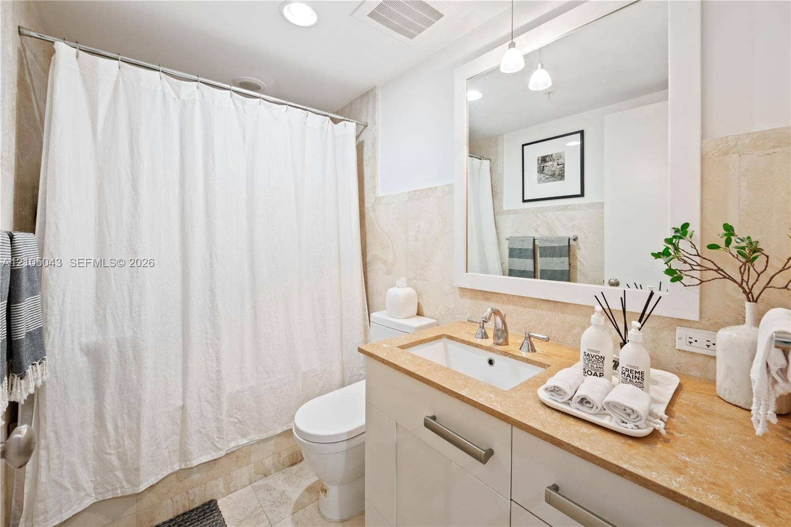 3540 Main Highway, #207, Miami, FL 33133 Stackable laundry unit housed within a closet featuring white louvered doors