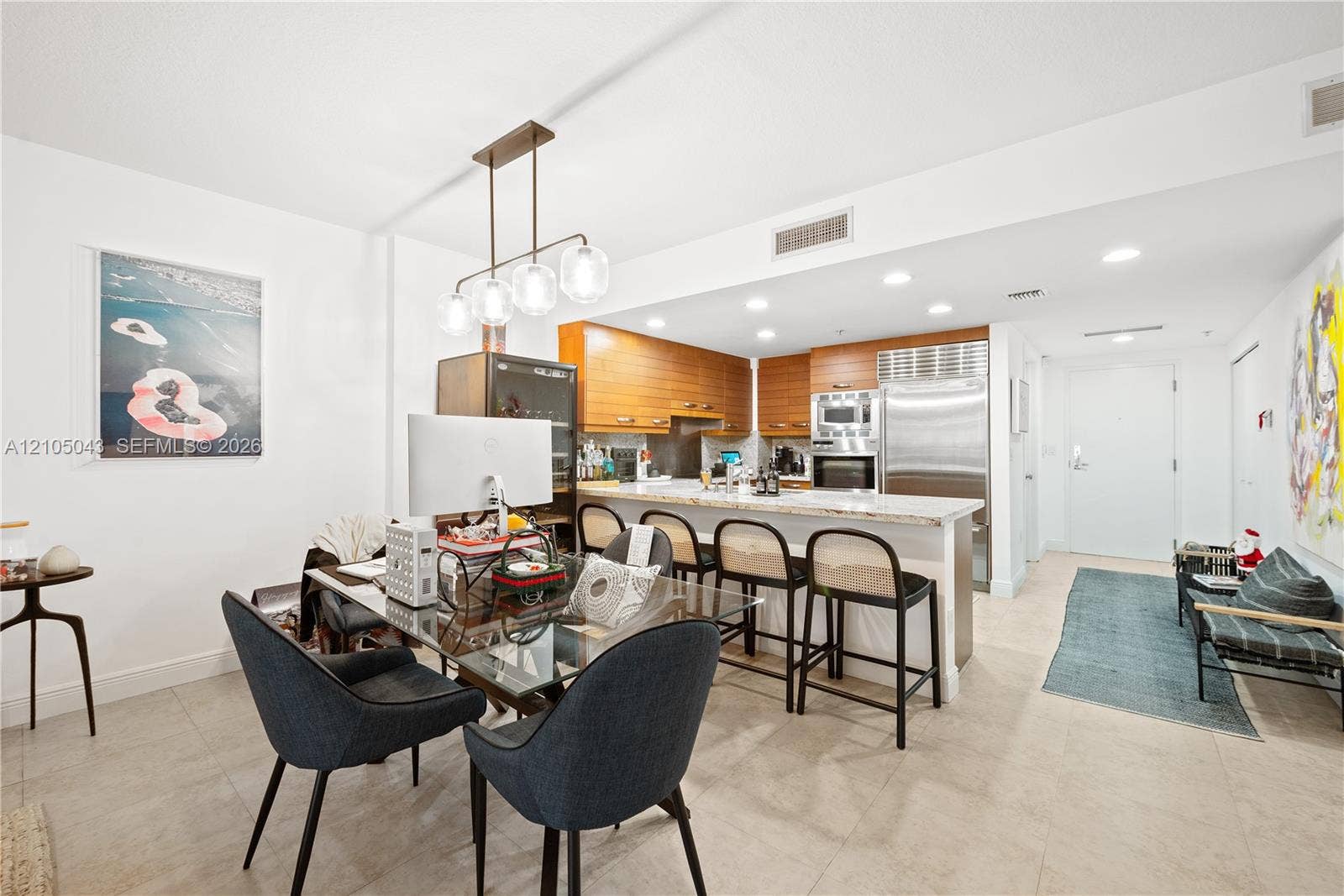 3540 Main Highway, #207, Miami, FL 33133 Kitchen featuring horizontal-grain cabinetry, stone countertops, stainless steel appliances including a built-in refrigerator and wall oven, and a metal backsplash