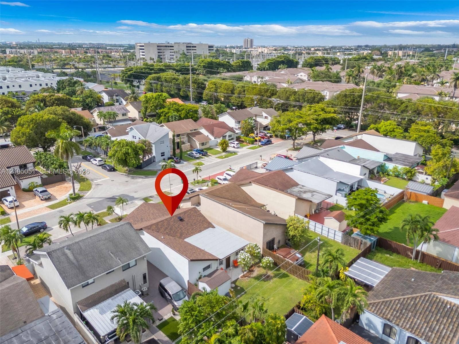 461 SW 89th Court, Miami, FL 33174 Aerial perspective featuring a multi-level residence with a multi-gabled roofline, private fenced yard, manicured lawn, and attached driveway