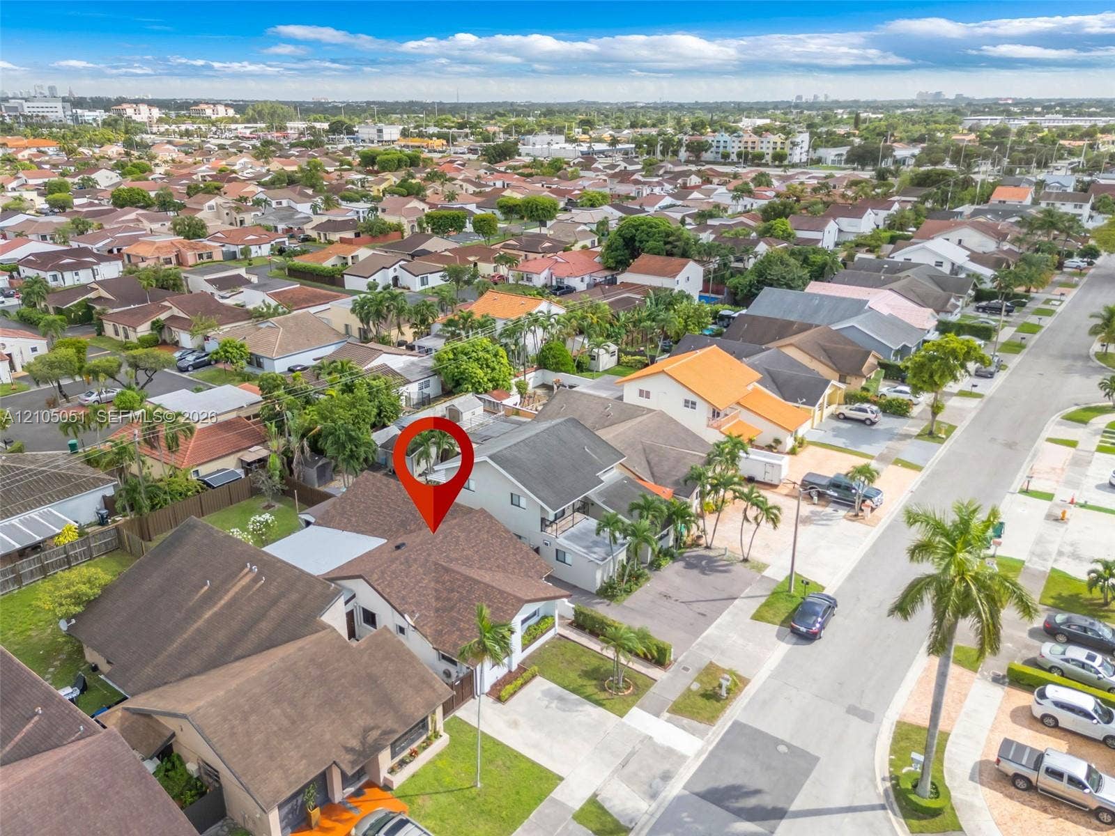 461 SW 89th Court, Miami, FL 33174 Aerial perspective of a multi-level residence featuring a multi-pitched shingle roof, concrete driveway, and established landscaping
