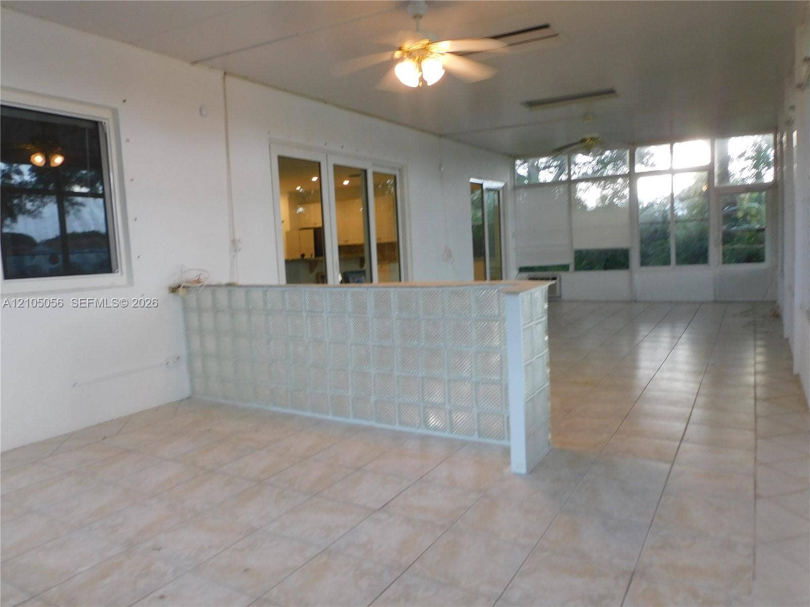 16729 Amber Lake, Weston, FL 33331 Enclosed patio featuring tile flooring, glass block partition, multiple windows, and two ceiling fans