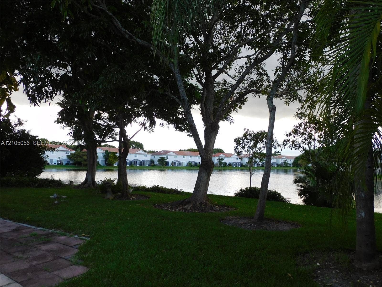 16729 Amber Lake, Weston, FL 33331 Green lawn with mature trees and visible water body
