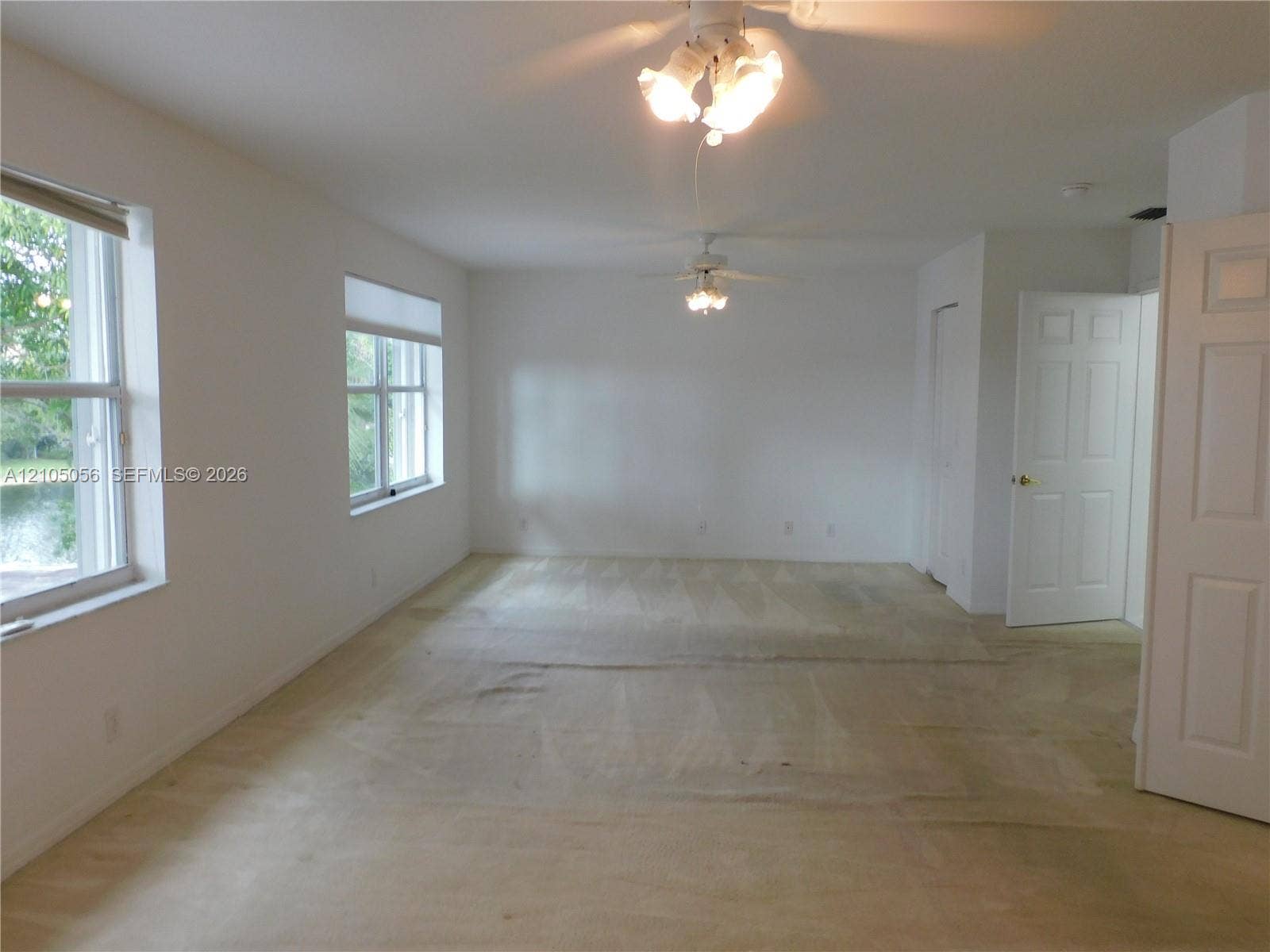 16729 Amber Lake, Weston, FL 33331 Expansive Primary Bedroom Suite with sitting area - easily converted to 5th bedroom as it was with developer option, multiple windows providing natural illumination, two ceiling fans, and a solid core door