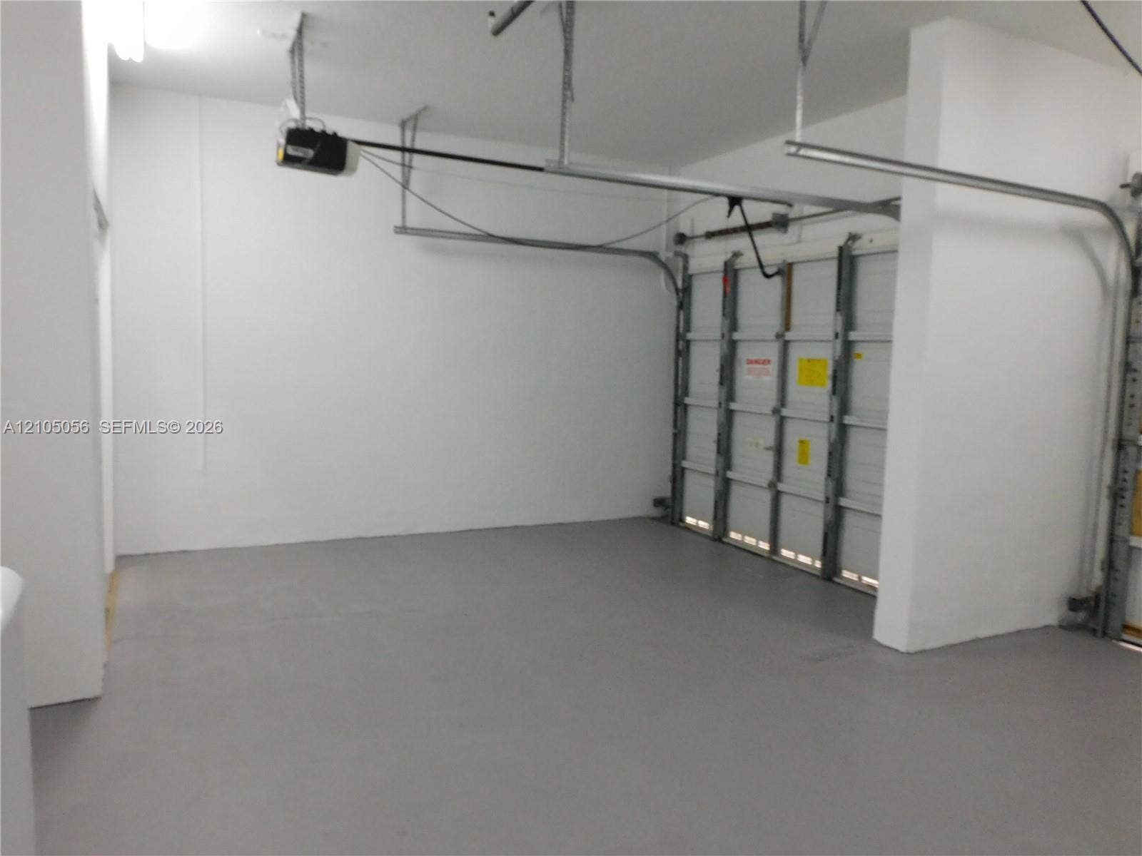 16729 Amber Lake, Weston, FL 33331 Garage space with painted walls, painted floor, and overhead lighting